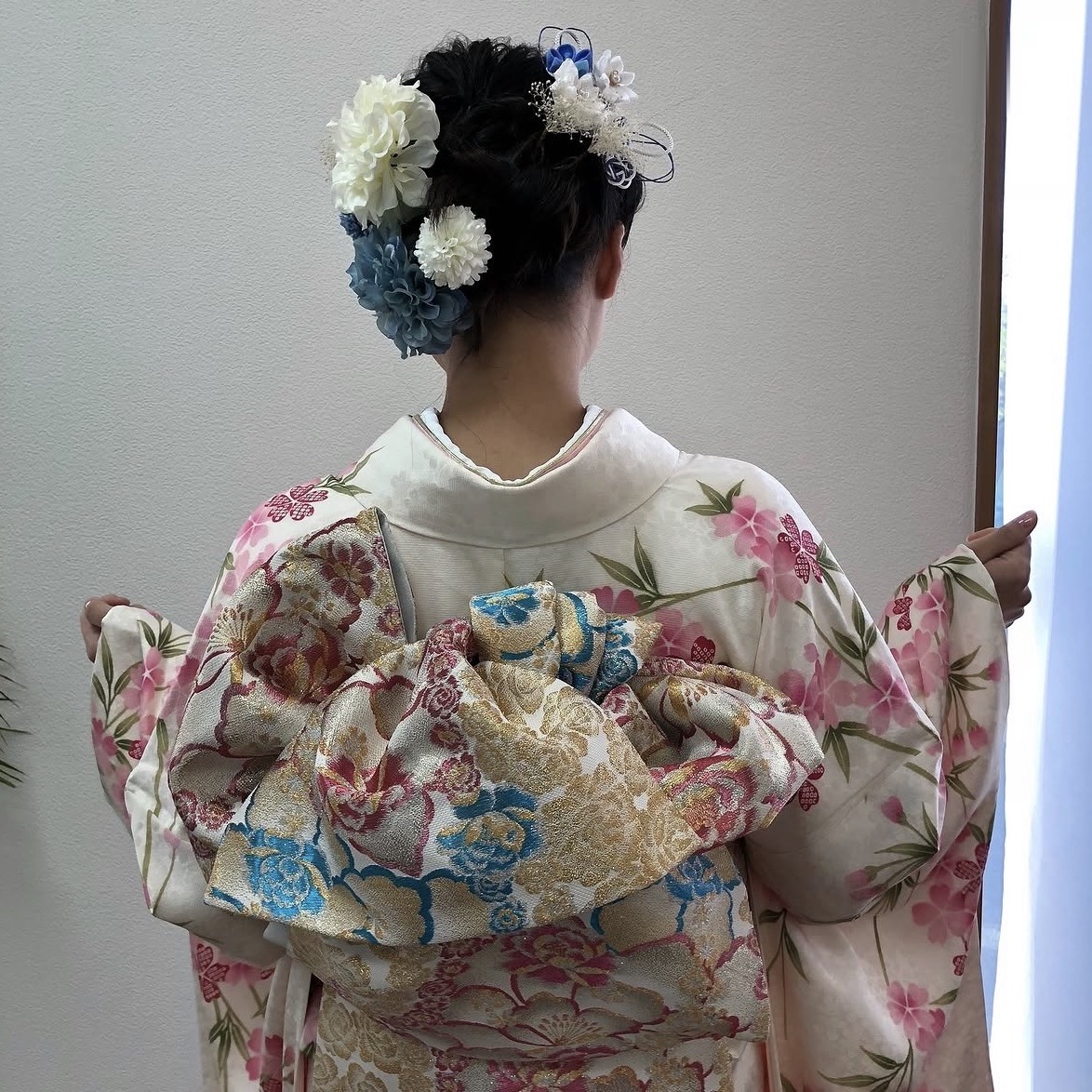 振袖の着付けと、生花風の髪飾りを添えたアップスタイル